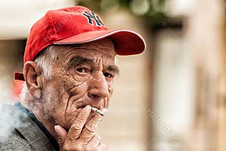 Old man smoking a cigarette on the bench in Zagreb center square
