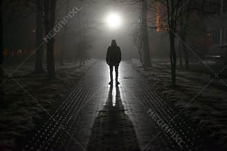 Lonely man in the fog at night