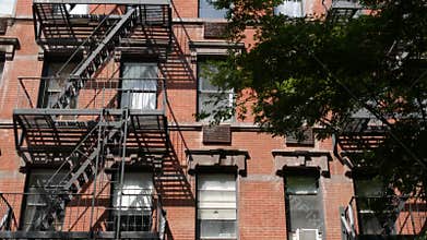 New York City building architecture, Manhattan. Residential house exterior. Red brick, fire escape.
