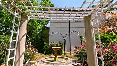footage of a water fountain with lush green trees and colorful flowers at Huntington Library and Botanical Gardens in San Marino