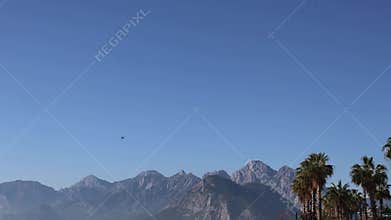 The F16 fighter performs aerobatics over the sea against the background of mountains