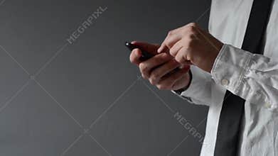 Businessman using smartphone. Hands scrolling and typing the screen.