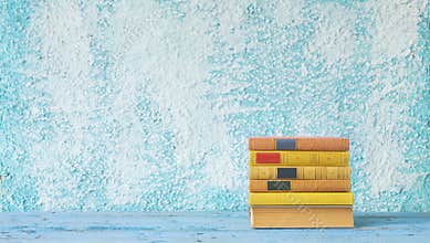 Stack of books on blue wall