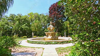 footage on a footpath in a garden with lush green trees and flowers at Huntington Library and Botanical Gardens in San Marino