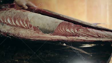 Fish production guys undress a body of big swordfish clean from skin make fillet