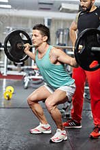 Doing barbell squats with personal instructor