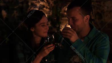 Young couple in love drinking wine and kissing by