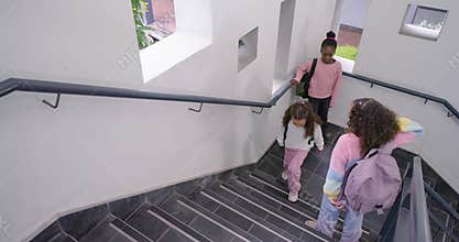 African American teen girls starting school stairs adjusting backpacks heading to class, copy space