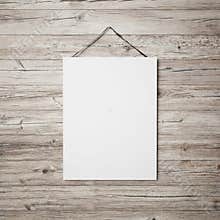 White blank poster hanging on leather belt on wood background