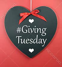 Giving Tuesday message greeting on black heart shape blackboard