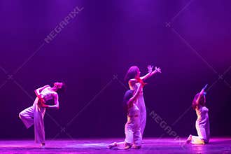 Expressive Contemporary Dancers Concluding Purple Lit Stage Performance
