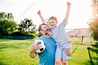 Dad and son sharing passion for football and active lifestyle.