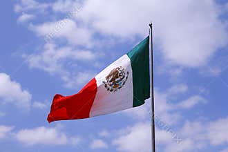 Mexican flag in a blue sky with clouds, mexico city I