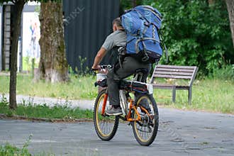Cyclist Carrying Large Travel Backpack Riding Bicycle