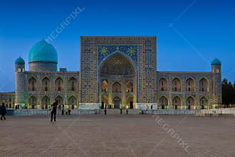 Tilla-Kari Madrasah at Registan Square in Samarkand illuminated at dusk with turquoise domes and intricate tilework. Ideal for