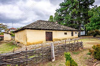 BULGARIA: Traditional village house with stone fence and tile roof