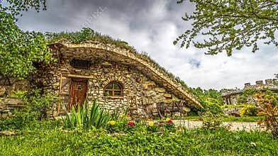 BULGARIA: Earth-sheltered stone hut with sod green roof in countryside