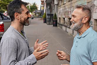 Senior man with a hearing impairment uses a hearing aid to communicate