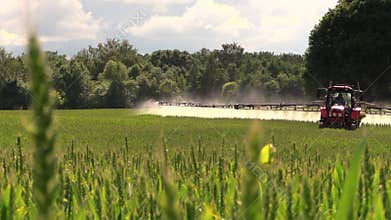 Tractor spray fertilize field with chemicals for crop protection