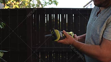 Man inserting battery into reciprocating saw and starting tool operation