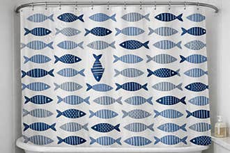 A blue and white shower curtain featuring colorful fish illustrations