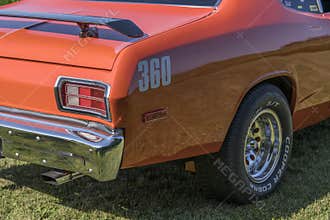 Bright orange 1974 Plymouth Duster featuring chrome rear details