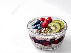 Delicious chia seed pudding layered with mixed berries and topped with fresh fruit and seeds is ready to be enjoyed
