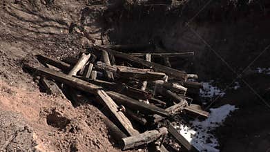 Worker throw pieces of wood into the pit