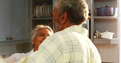 Senior couple dancing in kitchen