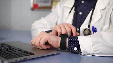 Close up shot of doctor wearing smart watch on his hand working in his cabinet.