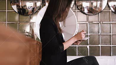 Beautiful young business woman eating a cake with a spoon in a cafe on a bar counter background.