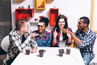 Playing game guess who am I, four friends have fun