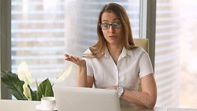 Smiling young confident businesswoman making vlog, looking at camera talking