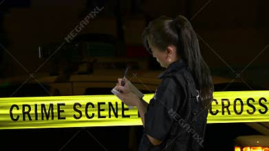 Female police officer taking notes at crime scene