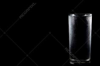 Glass with cold water on black background