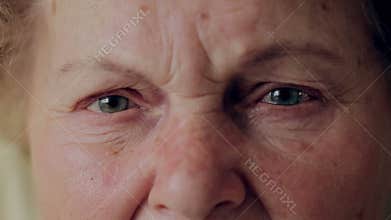 Close up photo of elderly woman eye. Senior portrait, happy old woman with eyeglasses smiling and looking at camera