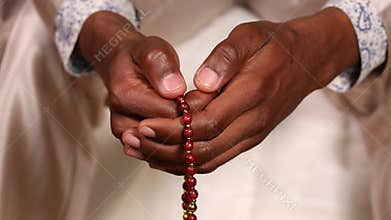 The man touches the rosary