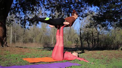 Women couple practicing acroyoga in the park at sunset