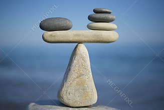 Balance of stones. To weight pros and cons. Balancing stones on the top of boulder. Close up.