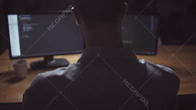 Rear view of freelancer programmer working at night