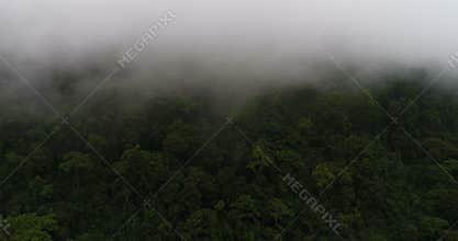 Flying over the high mountains in beautiful clouds