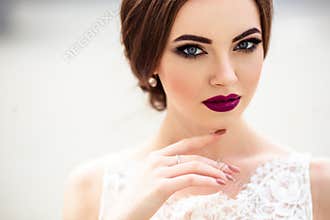 Gorgeous bride with fashion makeup and hairstyle in a luxury wedding dress