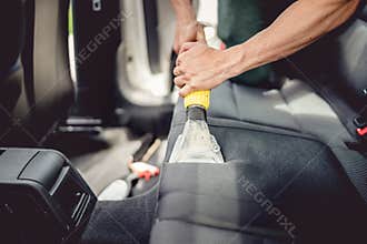 detailing and car care concept - Professional using steam vacuum for draining stains