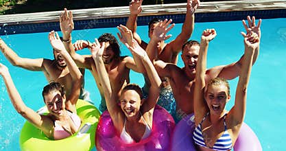 Group of happy friends having fun together in swimming pool