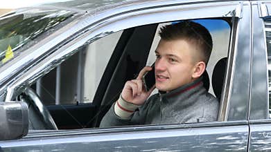Young man pulls over on the road to talk on his cell phone. Businessman in car speaking on the smartphone