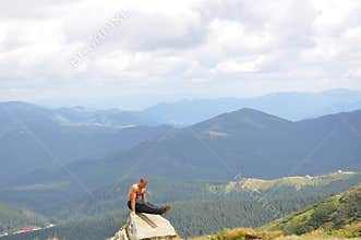 Male gymnast doing gymnastic exercise in the mountains