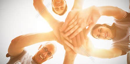 Happy volunteers stacking hands together