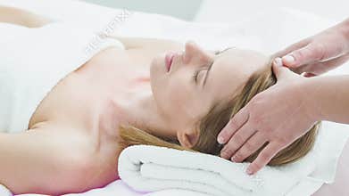 Skillful beautician massaging female head at salon