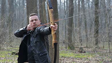 Man shoot with a bow in the forest