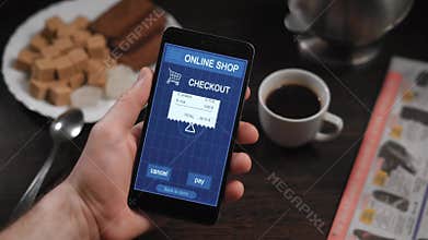 Paying a store receipe with a smartphone app. In the frame of man`s hands, a person pays for purchases in an online